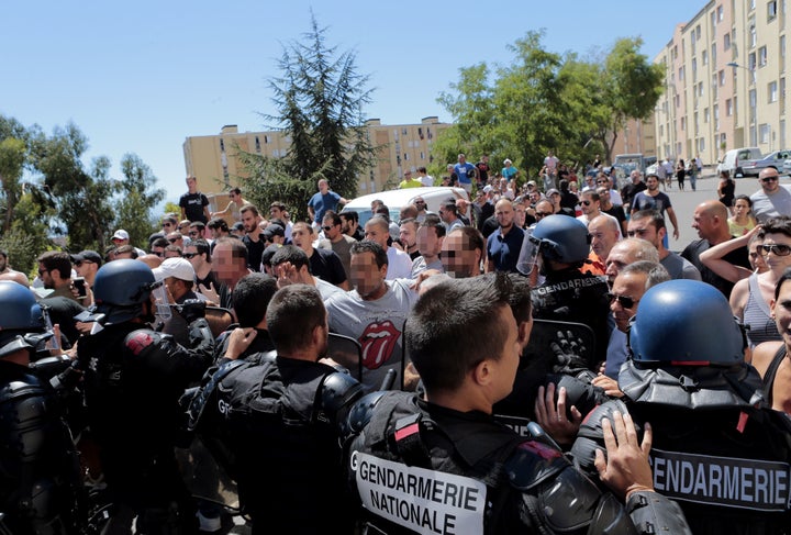 Hundreds walk into the cite des Monts surrounded by policemen in Lupino, Bastia, on the French Mediterranean island of C