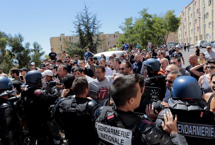 Hundreds walk into the cite des Monts surrounded by policemen in Lupino, Bastia, on the French Mediterranean island of Corsica on Sunday.