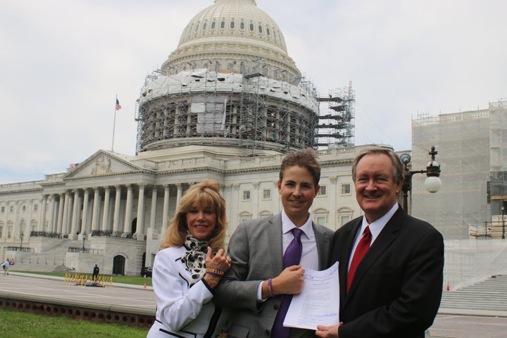 Charlie Smith (Co-Founder of Trevor's Trek Foundation), Trevor Schaefer (Founder of Trevor's Trek Foundation), and Senator Mike Crapo with the signed bill.