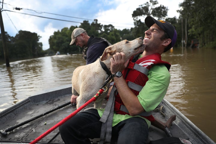 Mark Buchert from the Louisiana State Animal Response Team gets a lick from a dog he helped rescue from flood waters on Augus