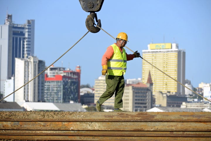 A Chinese construction worker helps build a new bridge against the skyline of Mozambique's capital Maputo April 15, 2016.