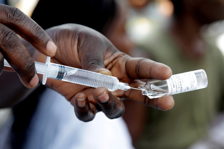 A Congolese health worker prepares to vaccinate a resident during an emergency campaign of vaccination against yellow fever i
