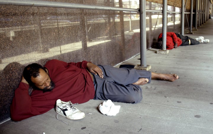 Homeless men sleep on a sidewalk along West 39th street in New York City, July 2, 2004.