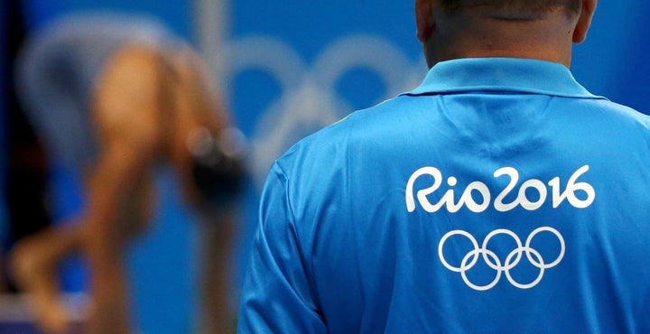 An unidentified Rio Olympics volunteer looks on at the aquatics center last week.