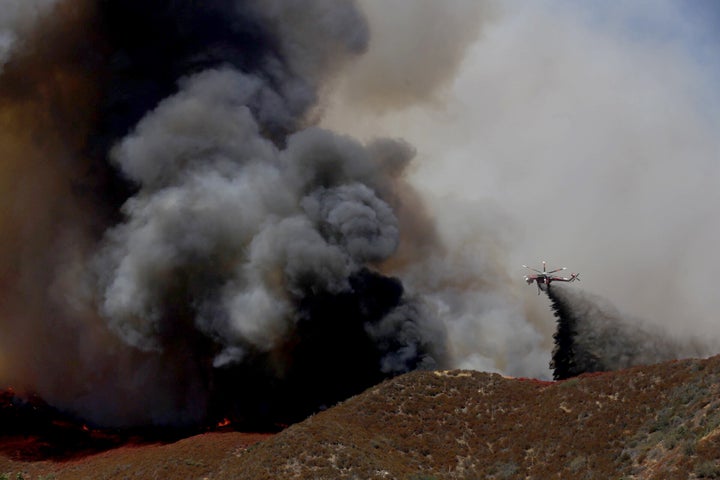 A helicopter battles the Blue Cut fire that broke out late Tuesday morning, August 16, 2016, in the Cajon Pass near Devore about 60 miles east of Los Angeles