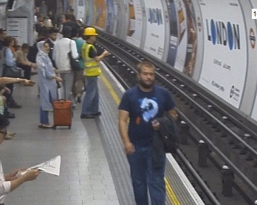 The man, wearing a hard hat and high-visibility jacket is seen waiting for a train at Tottenham Court Road Underground station on Tuesday