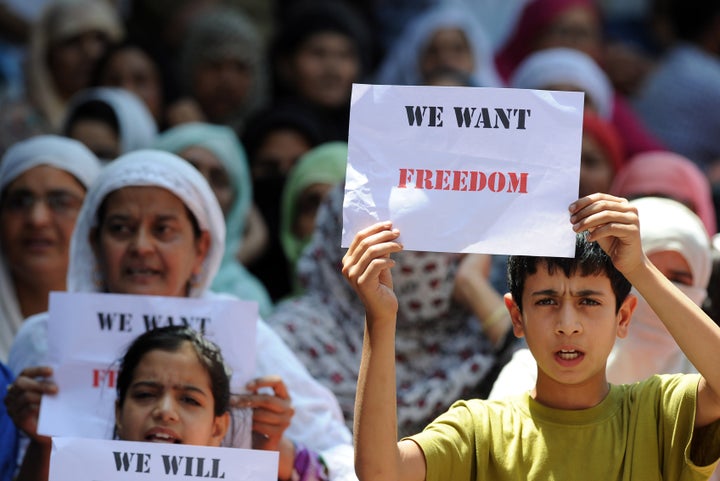 Young Kashmiri protestors hold placards at a protest against civilian killings in Kashmir's ongoing summer unrest, during a curfew in the Batmaloo area of Srinagar on August 17, 2016.