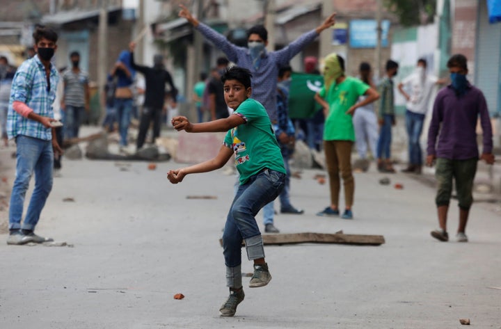 A protester throws stones towards the Indian police during a protest in Srinagar against the recent killings in Kashmir, Augu