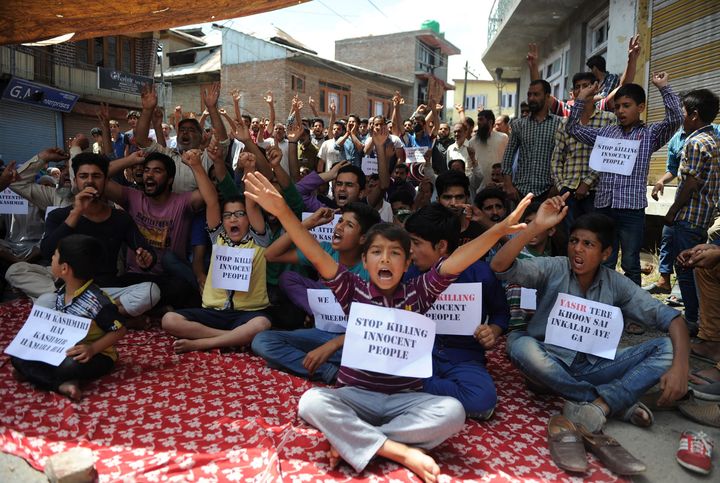 Young Kashmiri protestors hold placards at a protest against civilian killings in Kashmir's ongoing summer unrest, during a curfew in the Batmaloo area of Srinagar on August 17, 2016.