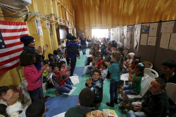Syrian refugee children play as they wait with their families to register their information at the U.S. processing centre for