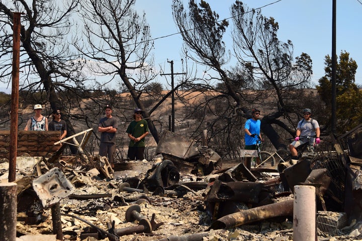 People look at the remains of the historic Summitt Inn after the Blue Cut Fire burnt the historic diner to the ground overnight, at the top of the Cajon Pass in Hesperia, California.