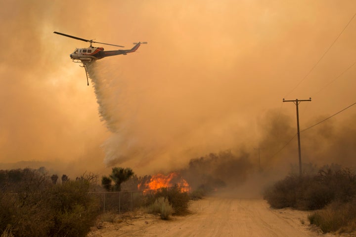 A helicopter makes a water drop at the Blue Cut wildfire in Phelan,California.