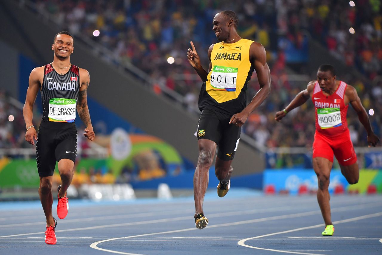 Jamaica's Usain Bolt jokes with Canada's Andre De Grasse after they crossed the finish line in the Men's 200m Semifinal in Rio de Janeiro on August 17, 2016.