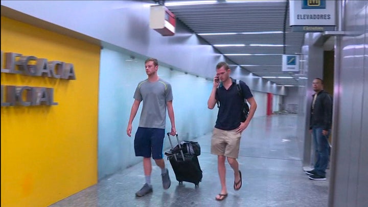 U.S. swimmers Jack Conger (L) and Gunnar Bentz walk into a police office of Rio de Janeiro's international airport after they were stopped from boarding a flight to the United States following their participation in the Rio 2016 Olympic Games.