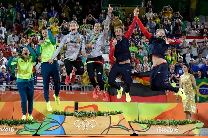 Medalists jump off the podium after the medals ceremony in the women's beach volleyball competition. 