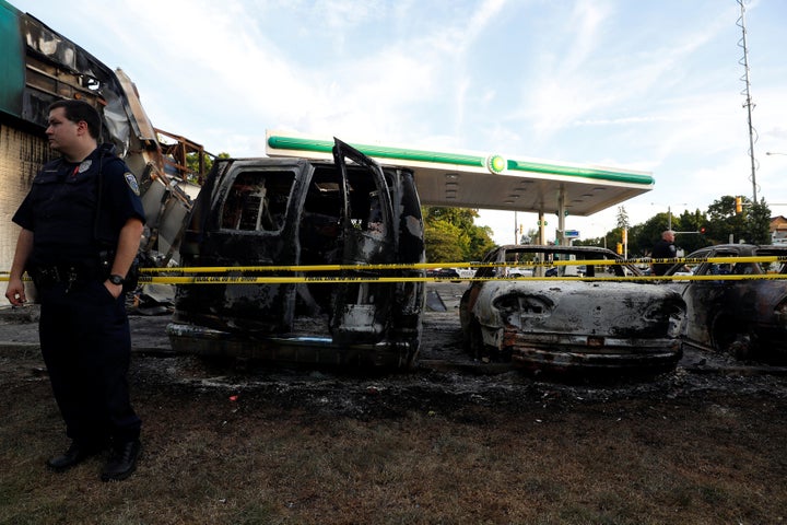 Police guard a burned gas station after disturbances following the police shooting of a man in Milwaukee, Wisconsin, U.S. Aug