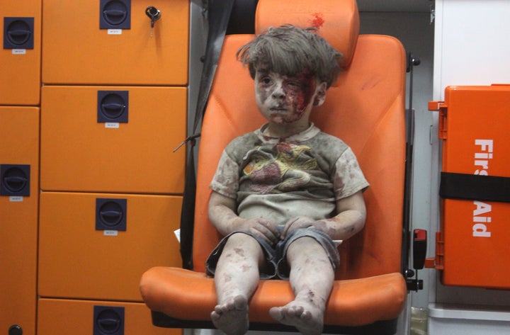 ALEPPO, SYRIA - AUGUST 17: 5-year-old wounded Syrian kid Omran Daqneesh sits alone in the back of the ambulance after he got injured during Russian or Assad regime forces air strike targeting the Qaterji neighbourhood of Aleppo on August 17, 2016.