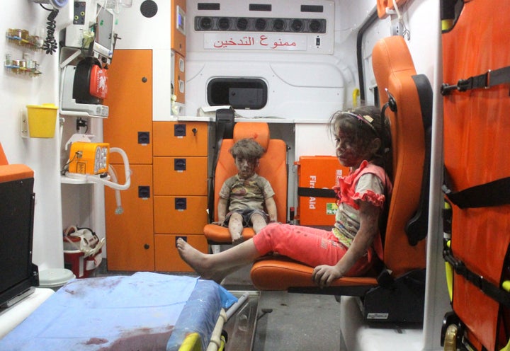 ALEPPO, SYRIA - AUGUST 17: 5-year-old wounded Syrian kid Omran Daqneesh (C) sits with his sister (R) in the back of the ambulance after they got injured during Russian or Assad regime forces air strike targeting the Qaterji neighbourhood of Aleppo on August 17, 2016.