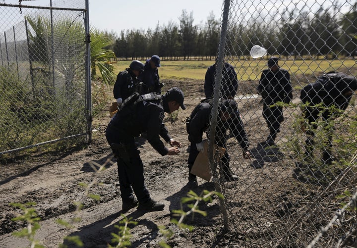 Police officers collect evidence at the ranch. The Jalisco New Generation Cartel hit security forces hard in the weeks before