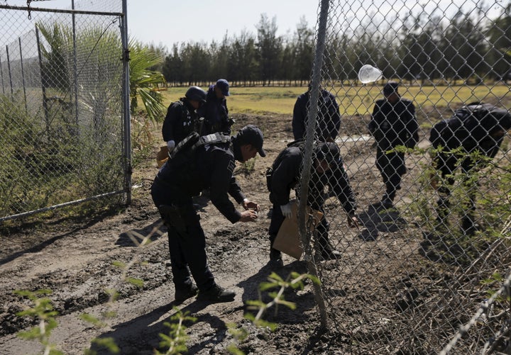 Police officers collect evidence at the ranch. The Jalisco New Generation Cartel hit security forces hard in the weeks before the firefight, killing six soldiers as they shot down their helicopter.