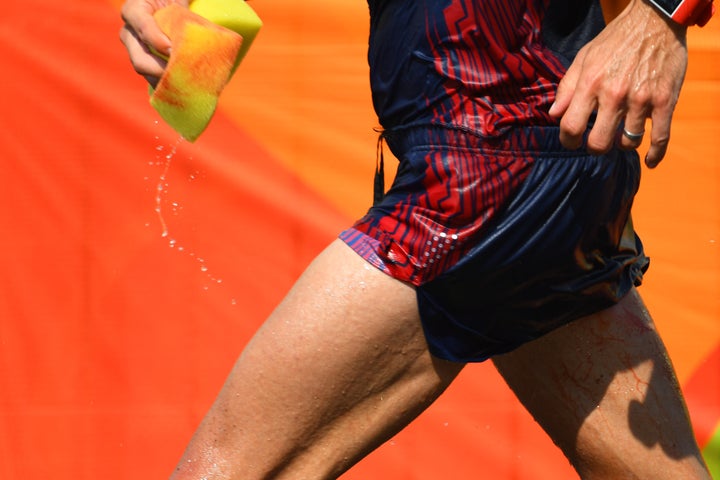 Diniz sponges away blood as he competes in the Men's 50km Race Walk.