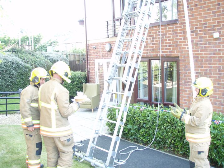The firefighter, preparing to climb the ladder. 