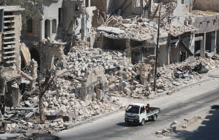 Russian cruise missiles targeted Syria on Friday. Pictured here, men ride on a pick-up truck past damaged buildings in the rebel-held Bab al-Hadid neighborhood of Aleppo on August 18.