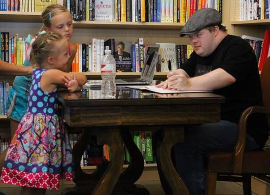 Marcus Sikora autographing for a young reader in Omaha, Ne