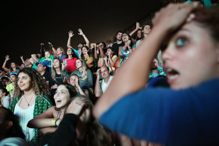 Brazilians on Leblon beach cheer during the shootout period of the Olympic men's soccer final in Rio de Janeiro, Aug. 20, 2016.