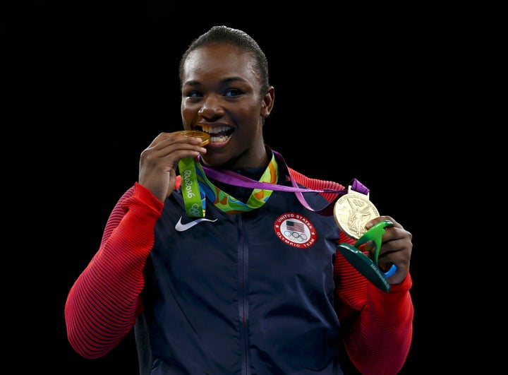 Gold medallist Claressa Shields (USA) bites her medal from Rio 2016 while posing with her other medal from London 2012.