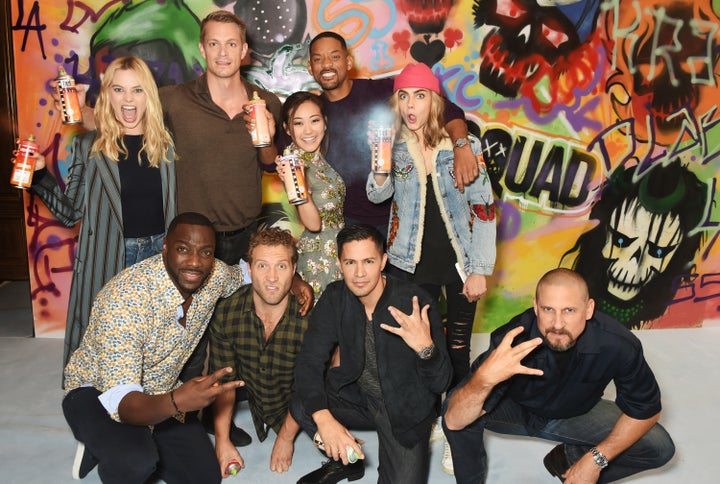 The cast of 'Suicide Squad' including Margot Robbie, Adewale Akinnuoye-Agbaje, Joel Kinnaman, Jai Courtney, Karen Fukuhara, Will Smith, Jay Hernandez, Cara Delevingne and director David Ayer put the finishing touches on Graffiti artist Ryan Meades' mural ahead of tomorrow's film release on August 4, 2016 in London, United Kingdom.