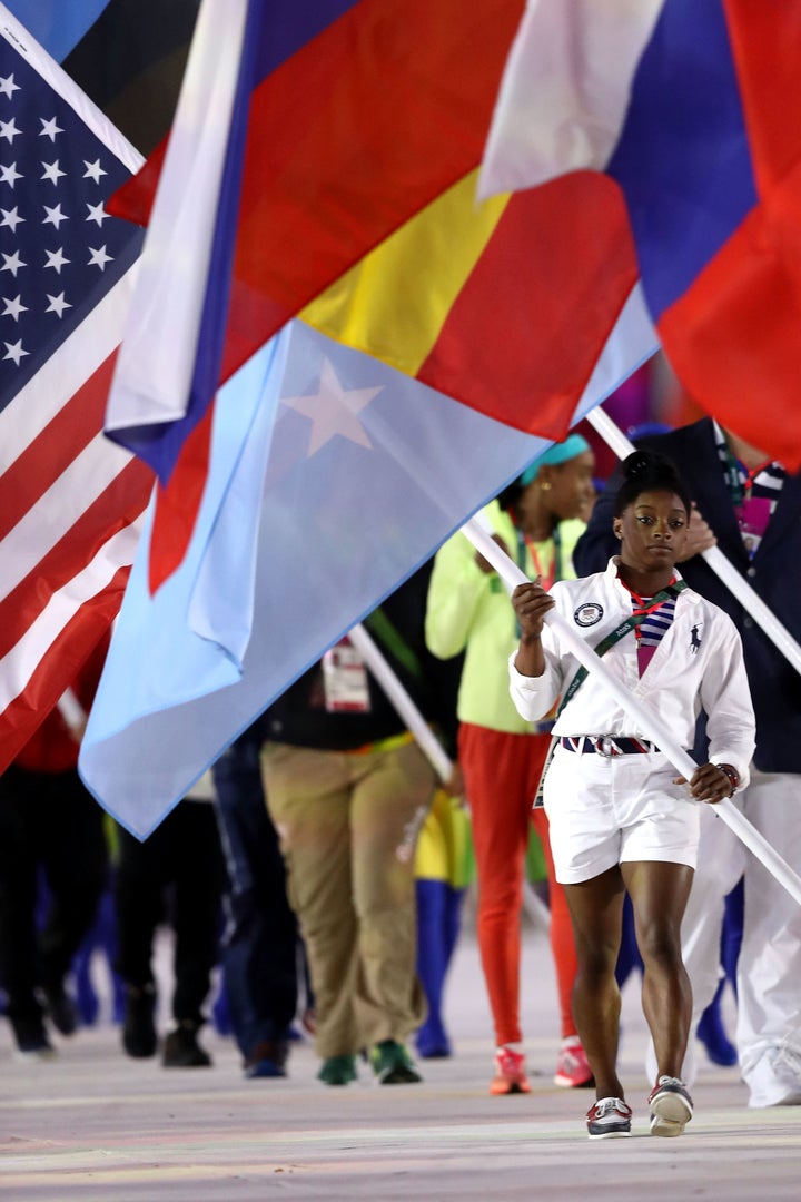 U.S. gymnastic phenom Simone Biles carries the American flag at the Rio Closing Ceremony.