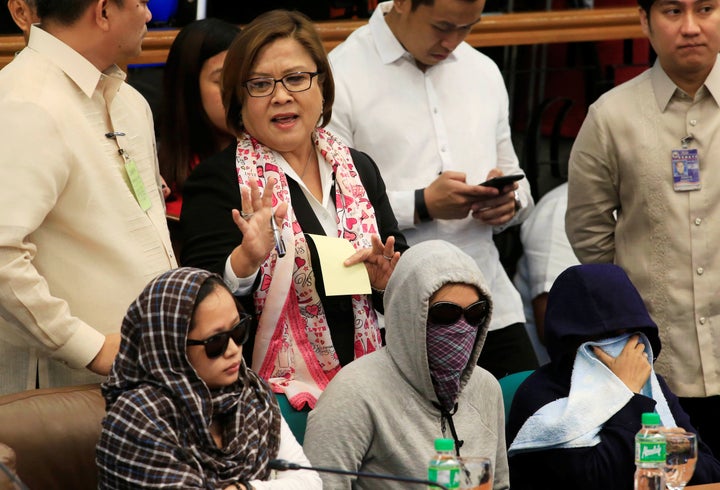 Senator Leila De Lima, chairperson of the Committee on Justice and Human Rights, gestures as she stands near relatives of slain people during a Senate hearing investigating drug-related killings at the Senate headquarters in Pasay city, metro Manila, Philippines August 22, 2016.