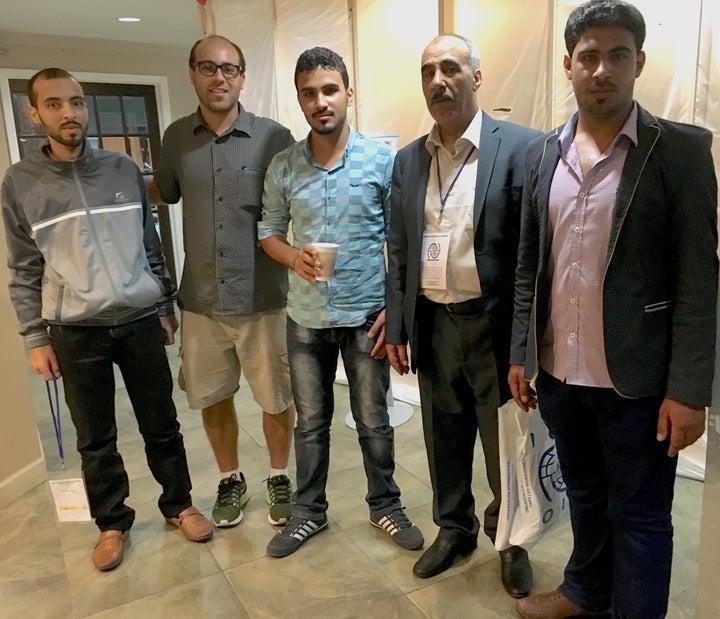 On their first night in America, the three brothers and their father pose with a fellow traveler.