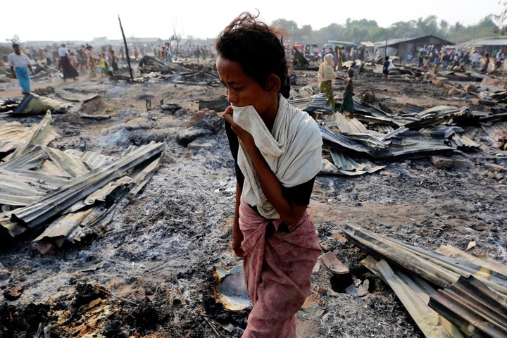 A woman walks among debris after fire destroyed shelters at a camp for internally displaced Rohingya Muslims in the western Rakhine State near Sittwe, Myanmar May 3, 2016.