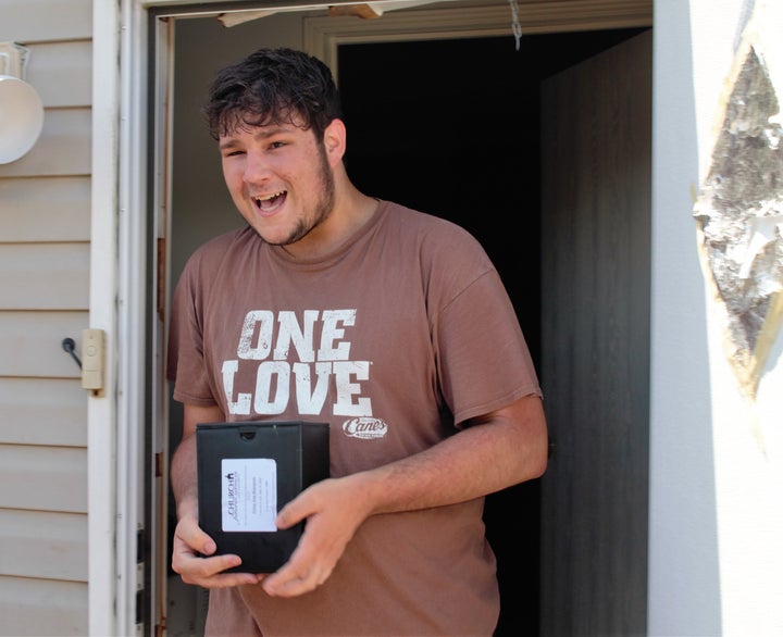 Cody Bourgeois, 20, emerges from his home in St. Amant, Louisiana, after the Cajun Navy helped him retrieve his mother's ashes.