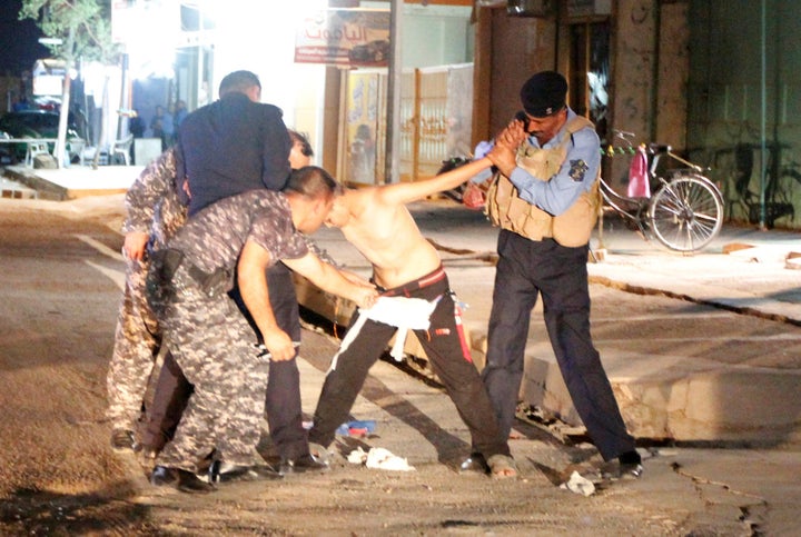 Iraqi security forces remove a suicide vest from a boy in Kirkuk, Iraq, August 21, 2016.