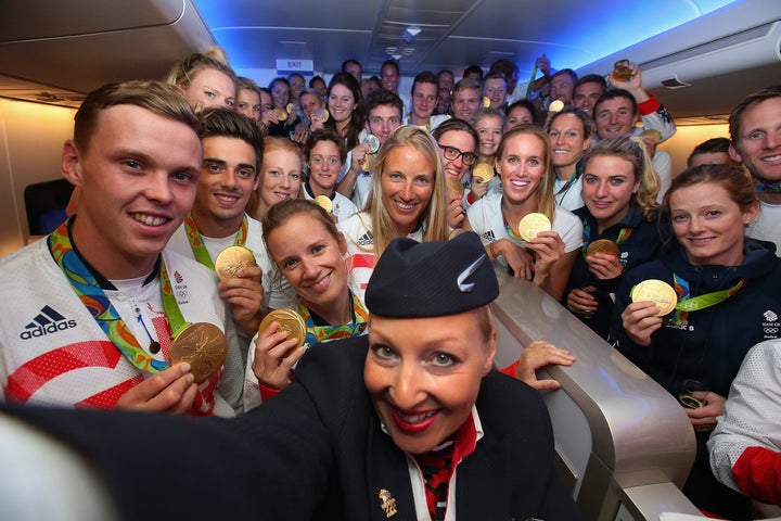 Gold medalists of Team GB pose for a selfie with a member of British Airways cabin crew,