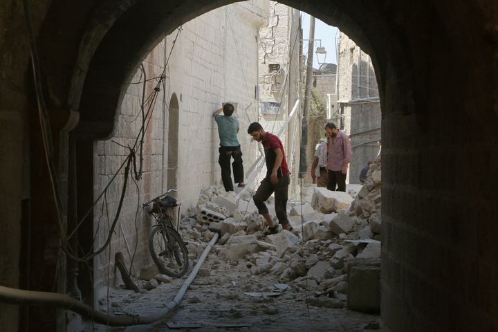 Residents inspect their damaged homes after an airstrike in rebel-held Aleppo