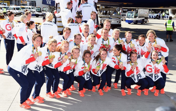 <strong>Members of the women's gold medal winning hockey team pose for photos after arriving home at Heathrow Airport.</strong>