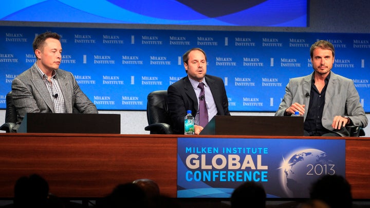 Elon Musk (L) and his brother Kimbal Musk (R), co-founder of The Kitchen Community, appear on a panel with interviewer Jeff Skoll, chairman of Participant Media and the Skoll Foundation.