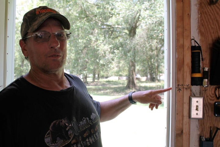 Jay Reynolds points to the water line in his garage.