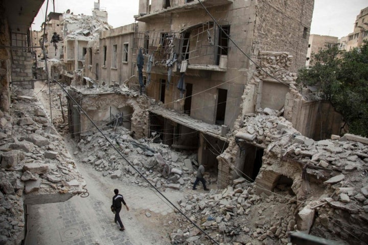 A man walks past destroyed buildings in a neighborhood of Aleppo, Syria, that was recently targeted by regime airstrikes.