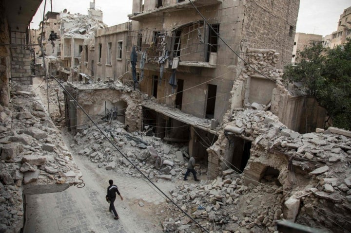 A man walks past destroyed buildings in a neighborhood of Aleppo, Syria, that was recently targeted by regime airstrikes. 