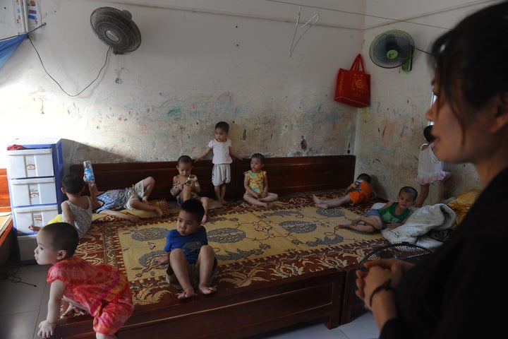 Volunteer (R) looking after young children inside a dormitory room at an orphanage in Hanoi. Thousands of disabled children are abandoned in Vietnam.