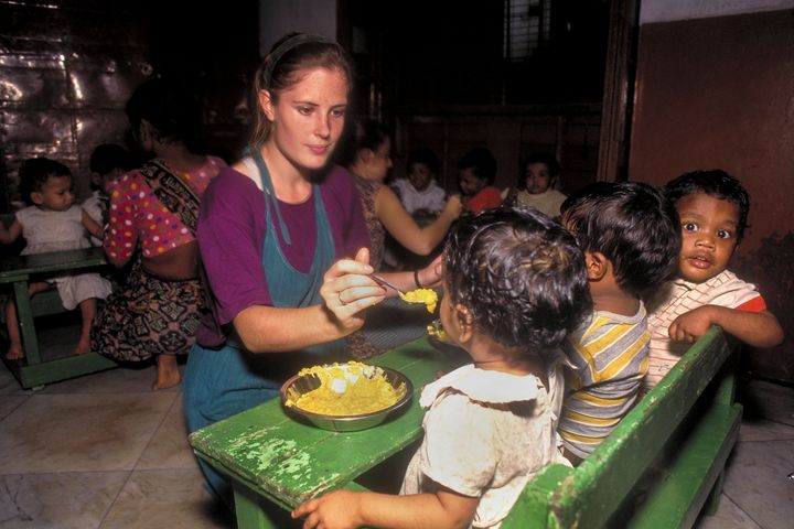Volunteer Kari Amber McAdam, a Dartmouth College student, feeds children at an orphanage in India.