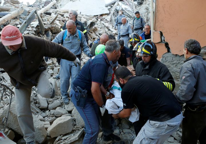 Rescuers remove a quake victim from the rubble in Amatrice, Italy.
