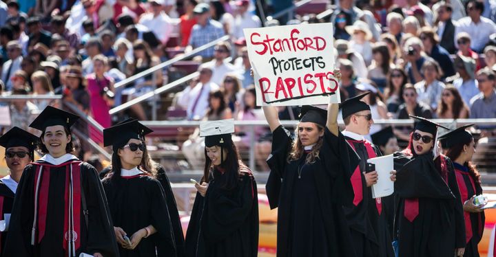A Stanford student holds a sign in protest before the 2016 graduation ceremony this past June. 