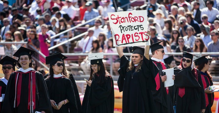 A Stanford student holds a sign in protest before the 2016 graduation ceremony this past June.