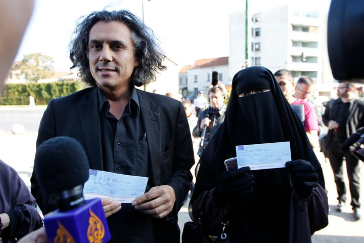 Hind Ahmas (R) is pictured in 2011 wearing a niqab and displayed a 120 euro fine. Nekkaz (L) is holding a second woman's fine.